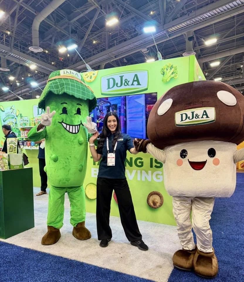 Two DJ&A mascots posing with the booth team