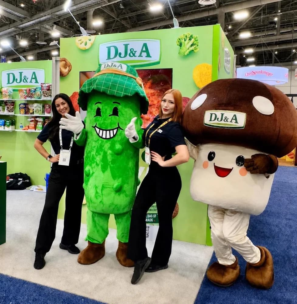 DJ&A mascots and staff at the Sweets and Snacks Expo booth