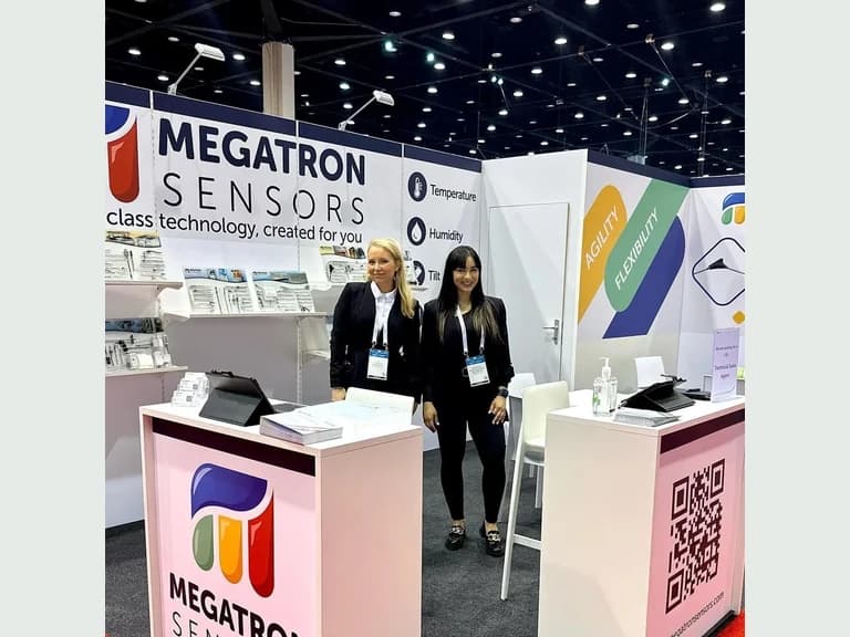 Megatron Sensors exhibit with two booth staff between branded counters