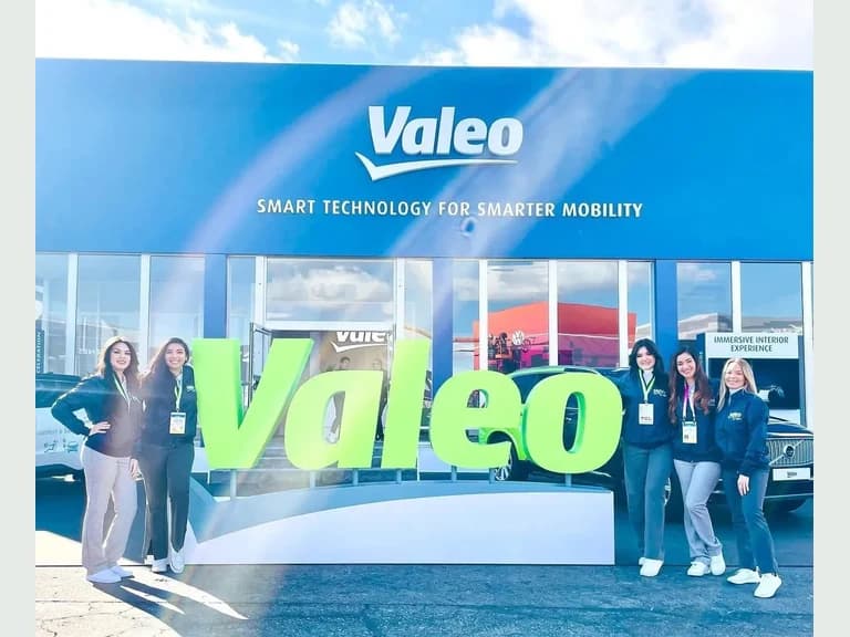 Valeo CES booth team standing beside the green Valeo sign