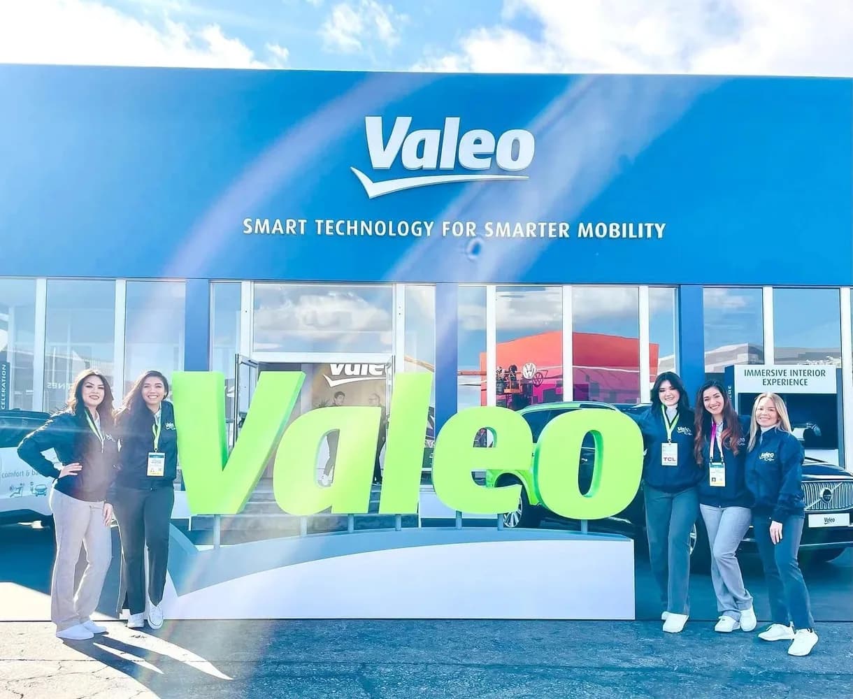 Valeo CES booth team standing beside the green Valeo sign