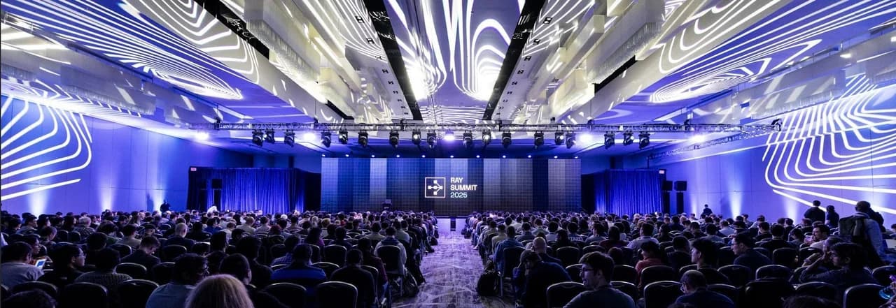 Ray Summit audience and presentation stage under an illuminated ceiling