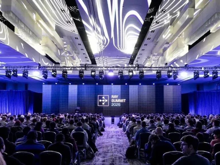 Ray Summit audience and presentation stage under an illuminated ceiling